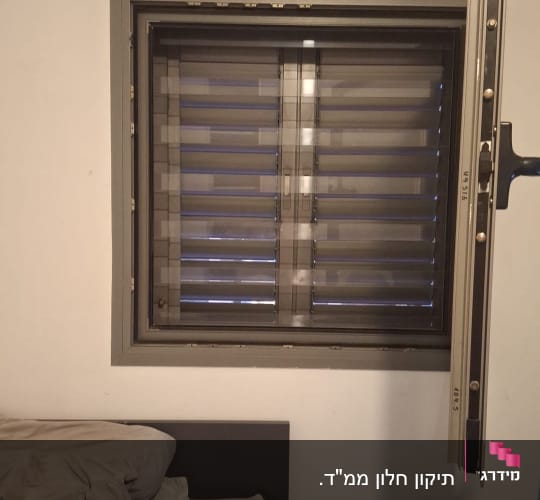 תריסים סגורים על חלון בחדר שינה עם מיטה